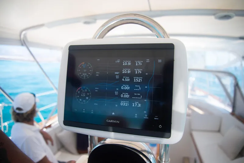 Tuatara Yacht Photos Pics Garmin navigation display on 1983 Little Harbor 63 yacht, with person relaxing in background.