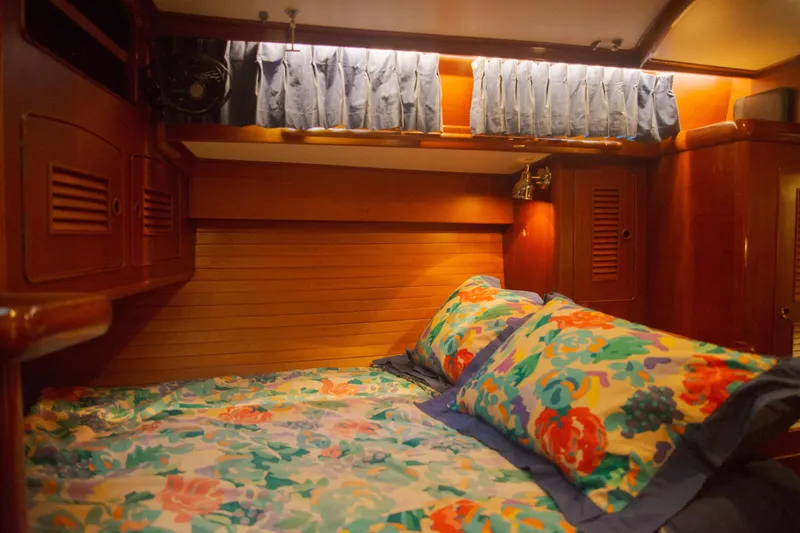Tuatara Yacht Photos Pics Cozy cabin interior of 1983 Little Harbor 63 yacht with floral bedding and wooden paneling.