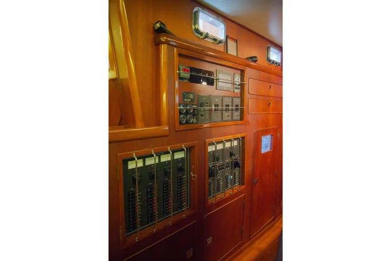 Tuatara Yacht Photos Pics Control panel inside 1983 Little Harbor 63 yacht, featuring wooden cabinetry and electrical systems.