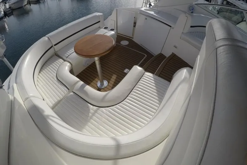 Grand Cru Yacht Photos Pics Luxurious seating area on 2005 Cruisers Yachts 340 Express with wooden table and white upholstery.