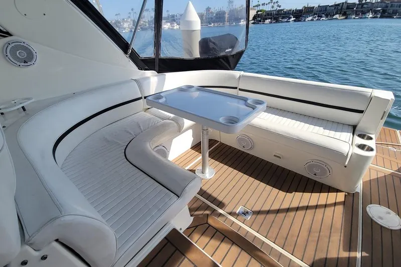 Grand Cru Yacht Photos Pics 2005 Cruisers Yachts 340 Express interior with white seating and table, docked by water.