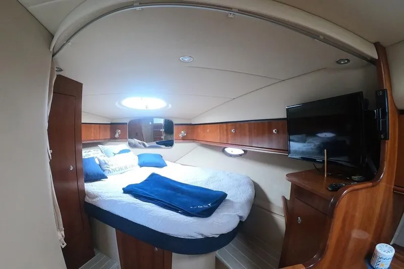 Grand Cru Yacht Photos Pics 2005 Cruisers Yachts 340 Express cabin interior with bed, TV, and wooden furnishings.