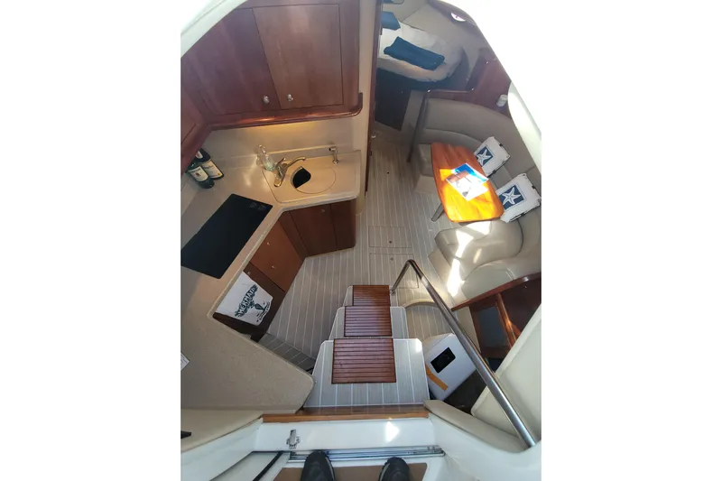 Grand Cru Yacht Photos Pics 2005 Cruisers Yachts 340 Express interior with kitchen, seating area, and wooden cabinetry.