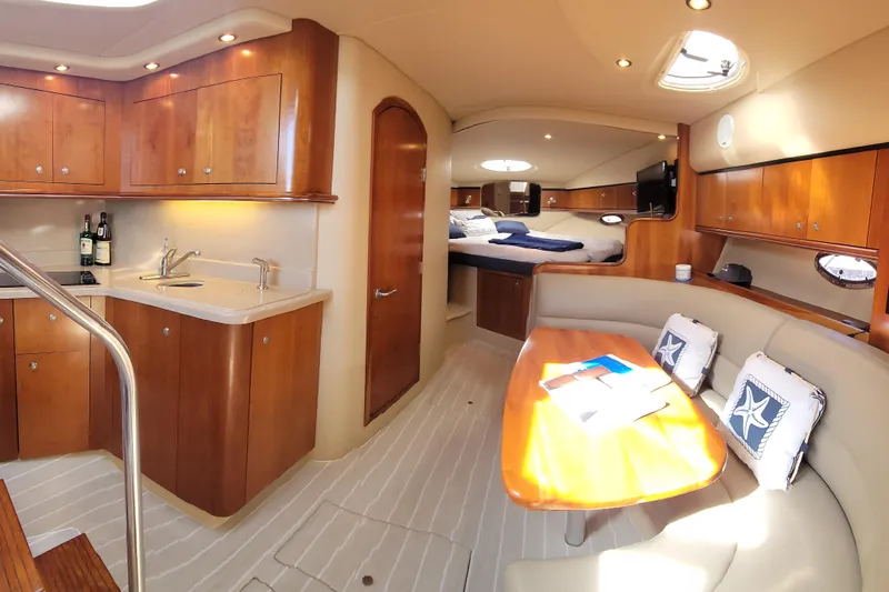 Grand Cru Yacht Photos Pics Luxurious interior of 2005 Cruisers Yachts 340 Express with kitchen and seating area.