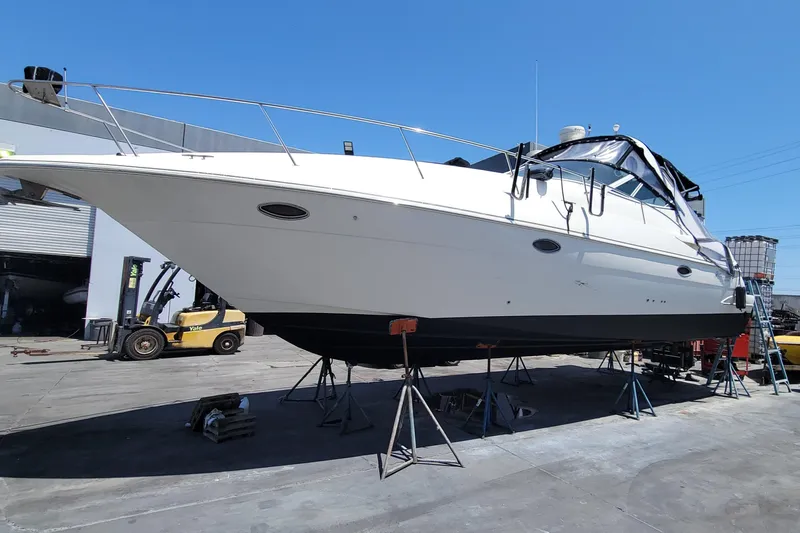 Grand Cru Yacht Photos Pics 2005 Cruisers Yachts 340 Express on stands in a boatyard under clear blue sky.