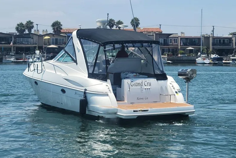 Grand Cru Yacht Photos Pics 2005 Cruisers Yachts 340 Express boat on water, docked near waterfront homes.