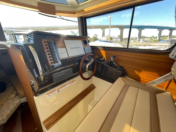  Yacht Photos Pics 2022 Ranger Tugs R-27 helm with Garmin navigation, wood accents, and bridge view.
