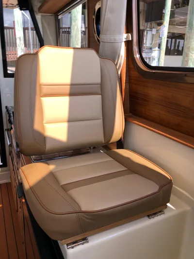  Yacht Photos Pics 2022 Ranger Tugs R-27 interior with tan leather seat and wooden accents.