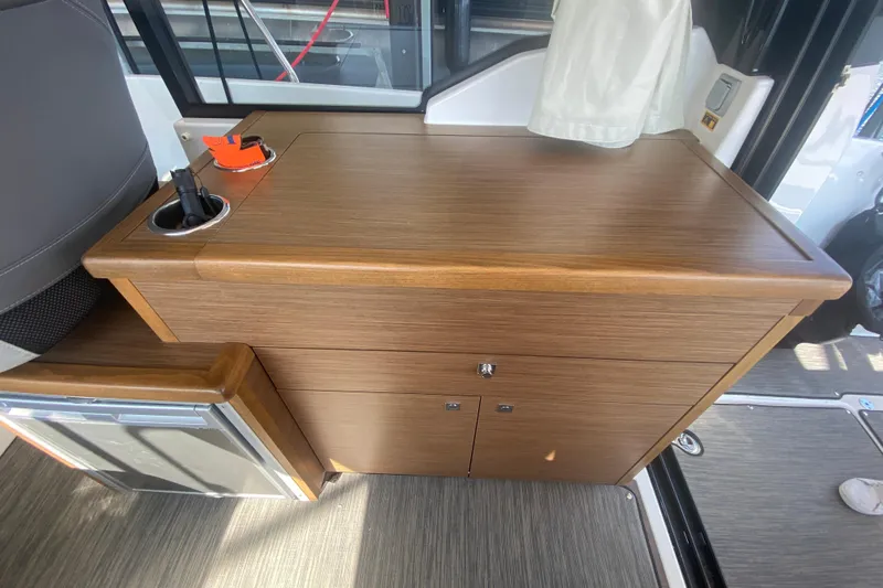  Yacht Photos Pics 2024 Jeanneau NC 895 interior with wooden cabinetry and compact design.