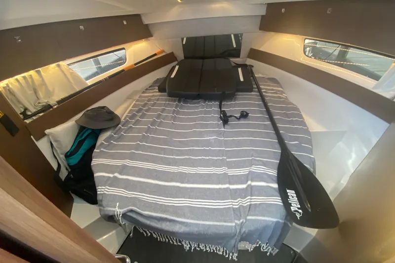  Yacht Photos Pics 2024 Jeanneau NC 895 cabin interior with striped bedding and paddle.