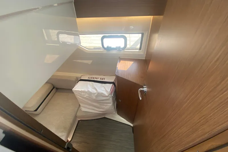  Yacht Photos Pics 2024 Jeanneau NC 895 cabin interior with life jackets and window view.