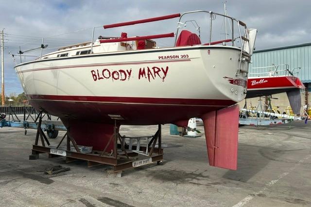 1986 Pearson 303 sailboat named "Bloody Mary" on dry dock, with red accents.