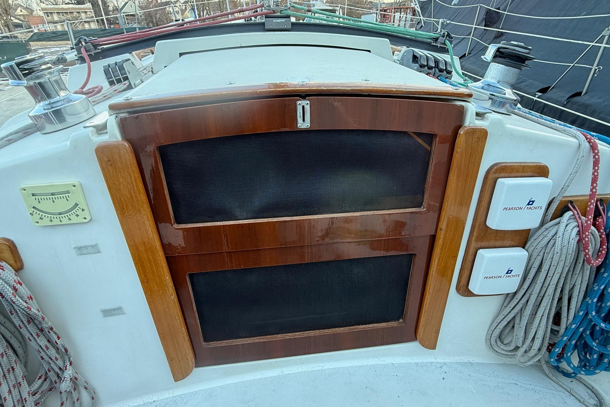 Cockpit of 1986 Pearson 303 sailboat with wooden hatch and nautical equipment.