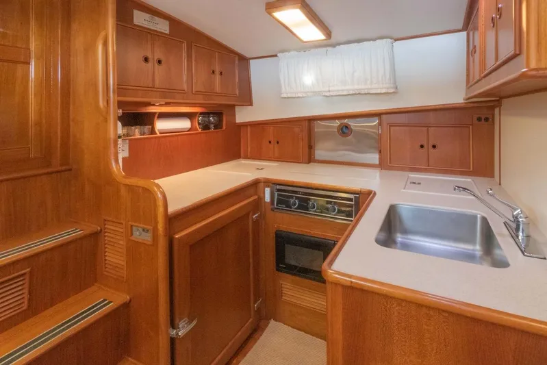 Salty Witch Yacht Photos Pics 1998 Grand Banks 38 Eastbay EX yacht kitchen with wooden cabinetry and modern appliances.