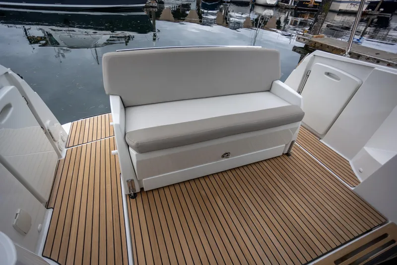 Myrt Yacht Photos Pics 2016 Jeanneau NC9 boat with cushioned seating and teak deck at a marina.
