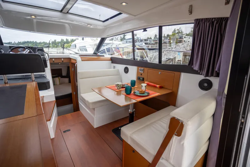 Myrt Yacht Photos Pics Interior of 2016 Jeanneau NC9 boat with dining area and panoramic windows.