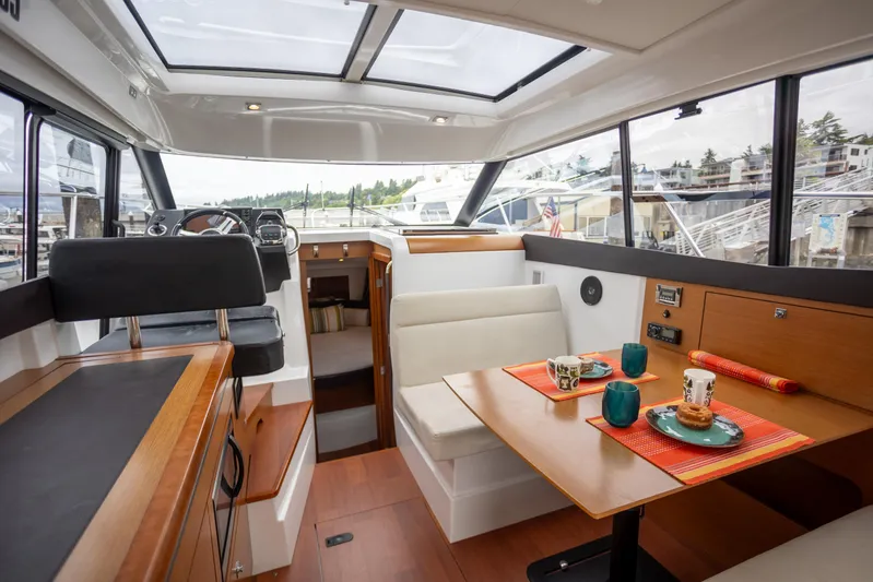 Myrt Yacht Photos Pics Interior of 2016 Jeanneau NC9 boat with dining area and helm, featuring modern design.