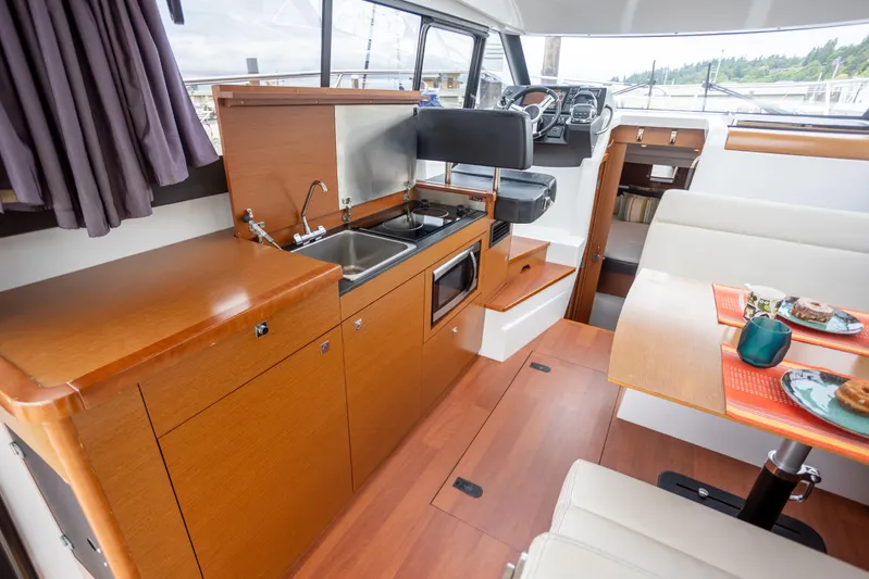 Myrt Yacht Photos Pics Interior of 2016 Jeanneau NC9 boat with kitchen and dining area.