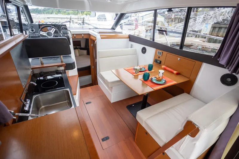 Myrt Yacht Photos Pics Interior of 2016 Jeanneau NC9 boat with kitchen and dining area.