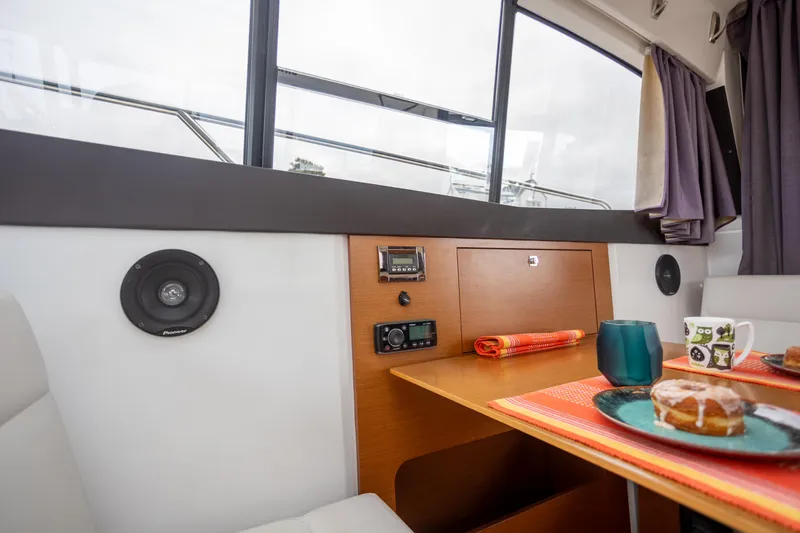 Myrt Yacht Photos Pics Interior of 2016 Jeanneau NC9 boat with dining area and window view.