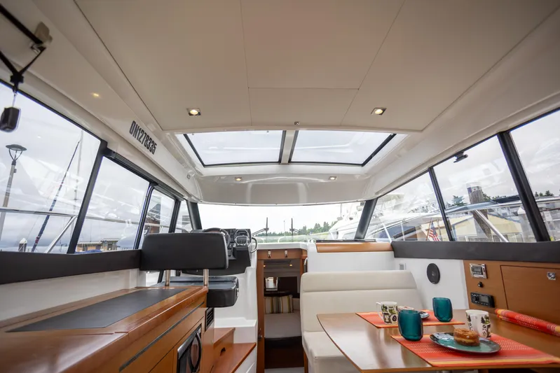 Myrt Yacht Photos Pics Interior of 2016 Jeanneau NC9 yacht with modern seating and panoramic windows.
