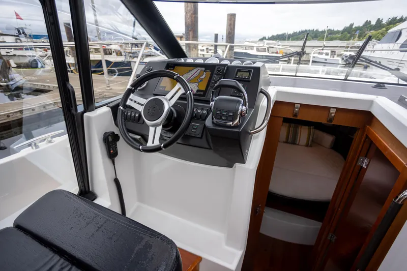 Myrt Yacht Photos Pics Helm of 2016 Jeanneau NC9 boat with modern controls and cabin view.