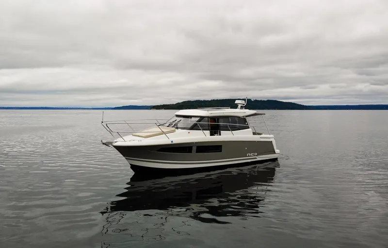 Myrt Yacht Photos Pics 2016 Jeanneau NC9 boat on calm water under cloudy sky.