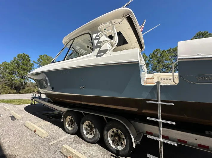 Dream Chaser Yacht Photos Pics 2021 Boston Whaler Realm 380 boat on a trailer, parked outdoors under clear blue sky.