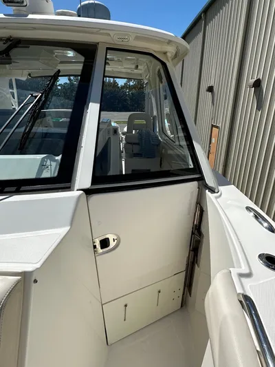 Dream Chaser Yacht Photos Pics 2021 Boston Whaler Realm 380 boat, side view, showcasing cabin entrance and sleek design.