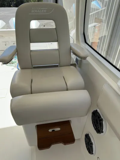 Dream Chaser Yacht Photos Pics 2021 Boston Whaler Realm 380 captain's chair with armrests and footrest, interior view.