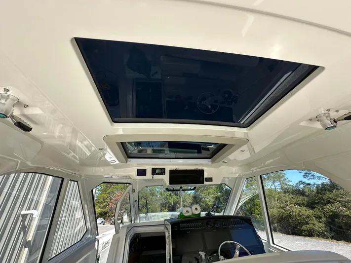 Dream Chaser Yacht Photos Pics Interior view of 2021 Boston Whaler Realm 380 boat with sunroof and control panel.