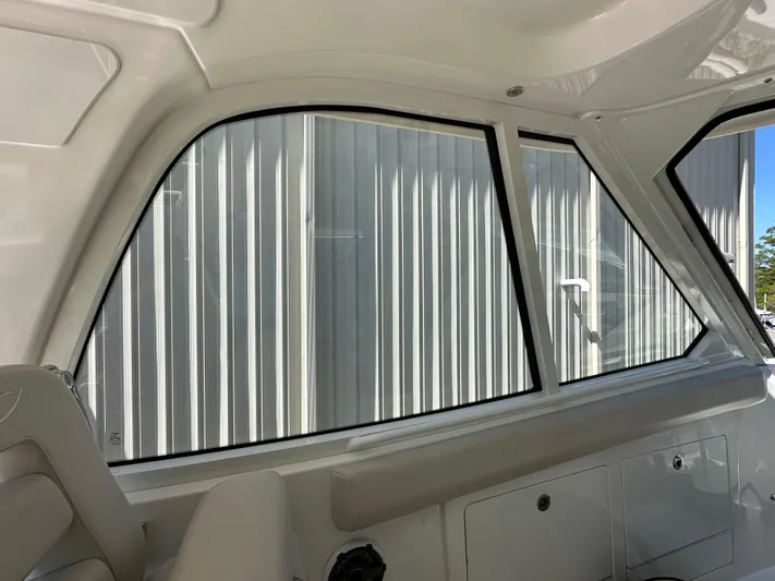 Dream Chaser Yacht Photos Pics Interior view of 2021 Boston Whaler Realm 380 boat, showcasing window and seating area.