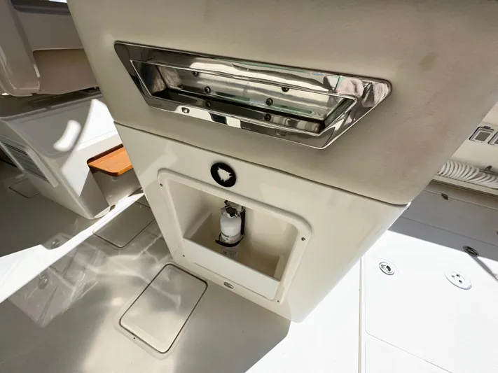 Dream Chaser Yacht Photos Pics 2021 Boston Whaler Realm 380 interior detail, featuring storage compartment and stainless steel accents.