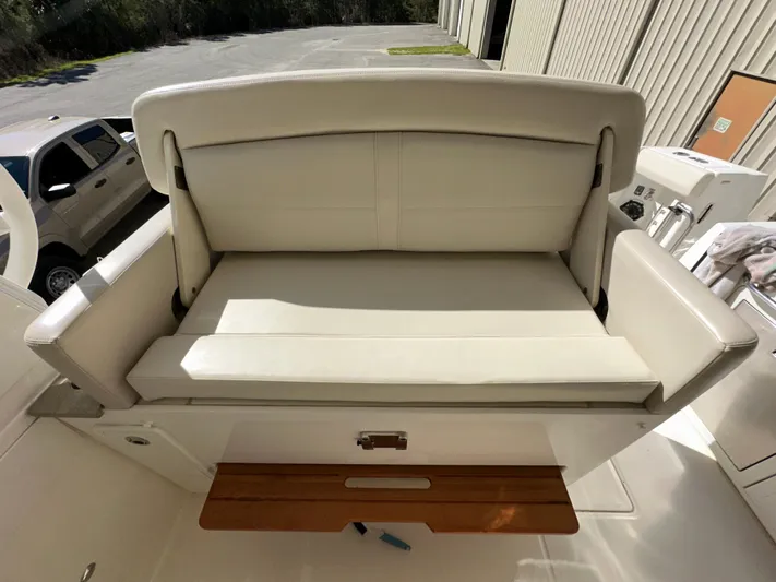 Dream Chaser Yacht Photos Pics 2021 Boston Whaler Realm 380 boat seat with white upholstery and wooden accents.