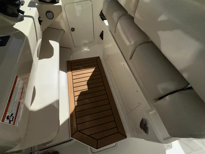 Dream Chaser Yacht Photos Pics Interior view of 2021 Boston Whaler Realm 380 boat, featuring seating and wooden flooring.