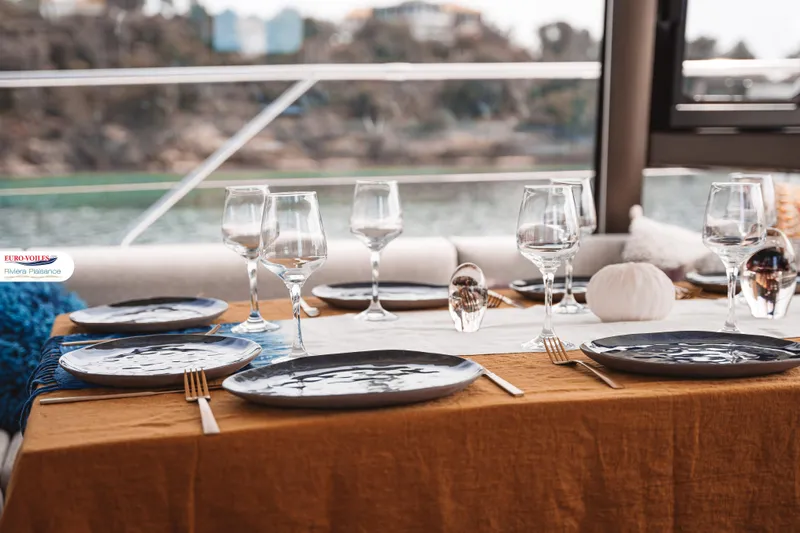 Sea Change Yacht Photos Pics Elegant dining setup on a 2021 Prestige 590 Fly yacht, featuring glassware and stylish tableware.