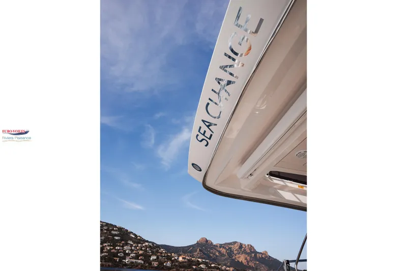 Sea Change Yacht Photos Pics Prestige 590 Fly yacht with "Sea Change" text, 2021 model, against a scenic coastal backdrop.