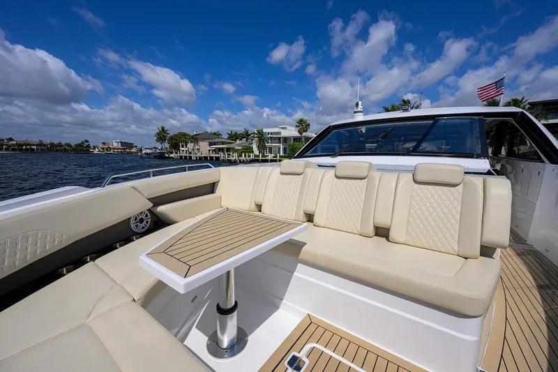 2024 Cruisers Yachts 50 Gls Outboard Yacht Photos Pics 2024 Cruisers Yachts GLS-OB luxury seating area with table, overlooking scenic waterfront.