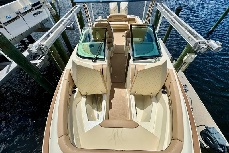  Yacht Photos Pics 2023 Chris-Craft Calypso 28 boat interior with seating and storage, docked by the water.