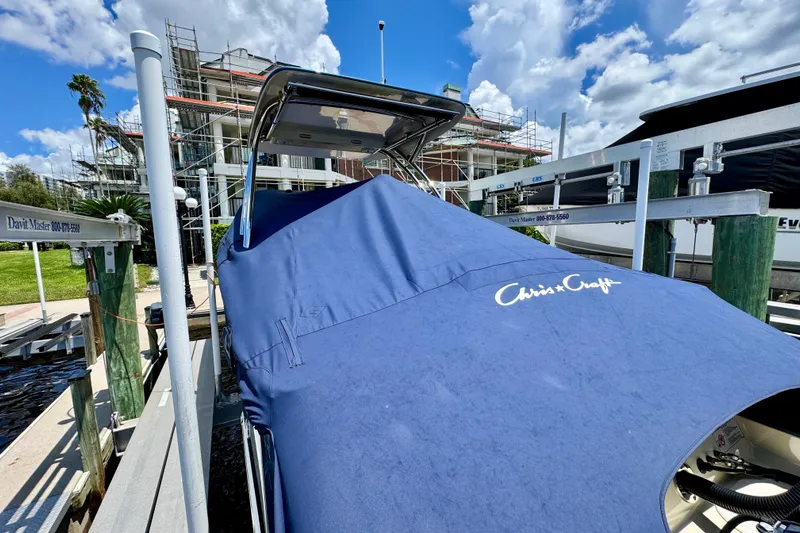  Yacht Photos Pics 2023 Chris-Craft Calypso 28 covered at dock, blue cover, sunny day, construction background.