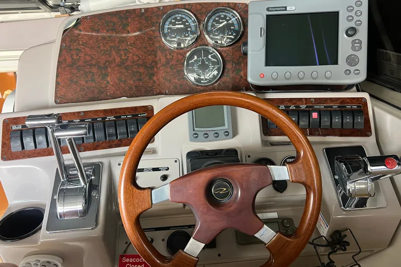 Bella Olivia Yacht Photos Pics Dashboard of a 2000 Regal Commodore 4160 boat with wooden steering wheel and navigation controls.