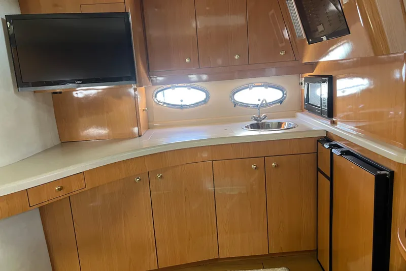 Bella Olivia Yacht Photos Pics Interior of 2000 Regal Commodore 4160 yacht kitchen with wood cabinets, sink, and appliances.