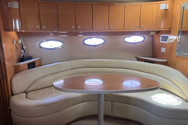 Bella Olivia Yacht Photos Pics Interior of 2000 Regal Commodore 4160 yacht with curved seating and wooden cabinetry.