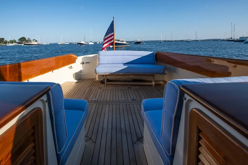 Eroica Yacht Photos Pics 2005 Hinckley Talaria 40 yacht deck with blue seating and American flag, overlooking a marina.