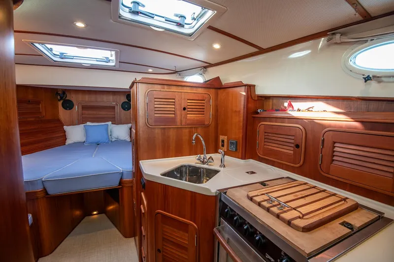 Eroica Yacht Photos Pics Interior of 2005 Hinckley Talaria 40 yacht with wood finish and compact kitchen.