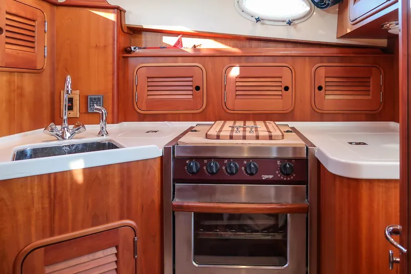 Eroica Yacht Photos Pics Hinckley Talaria 40 yacht kitchen interior with wood cabinetry and stainless steel appliances, 2005 model.