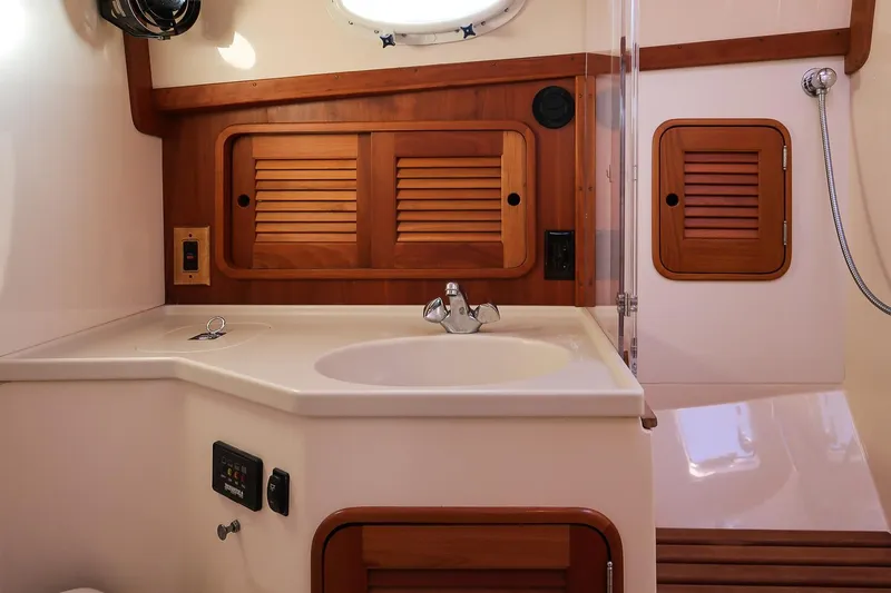 Eroica Yacht Photos Pics 2005 Hinckley Talaria 40 yacht bathroom with wooden cabinetry and modern fixtures.