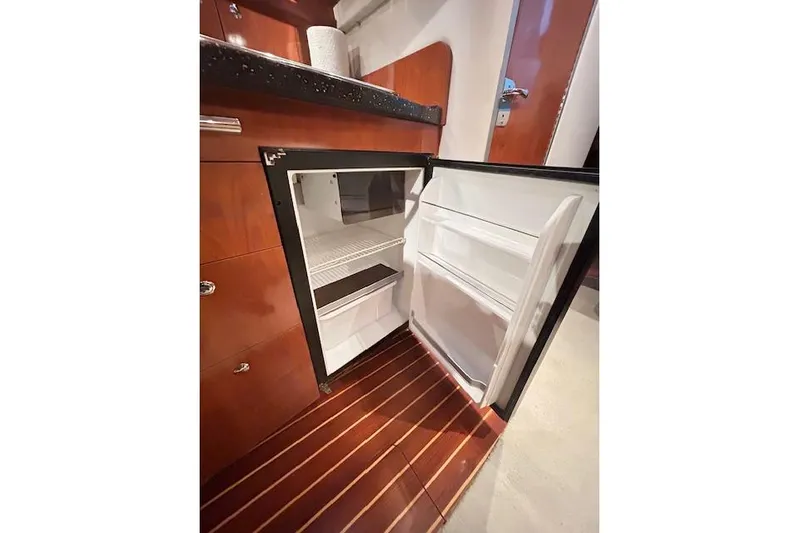 Gorgie Yacht Photos Pics Open mini fridge in 2008 Four Winns 338 Vista yacht interior, wooden flooring.