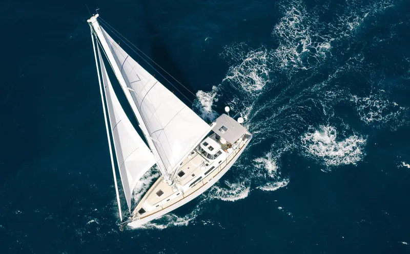 Outbound 46 Yacht Photos Pics Aerial view of 2025 Outbound 46 sailboat navigating through deep blue ocean waters.