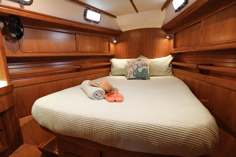Outbound 46 Yacht Photos Pics Luxurious cabin interior of 2025 Outbound 46 yacht with cozy bedding and wooden finish.